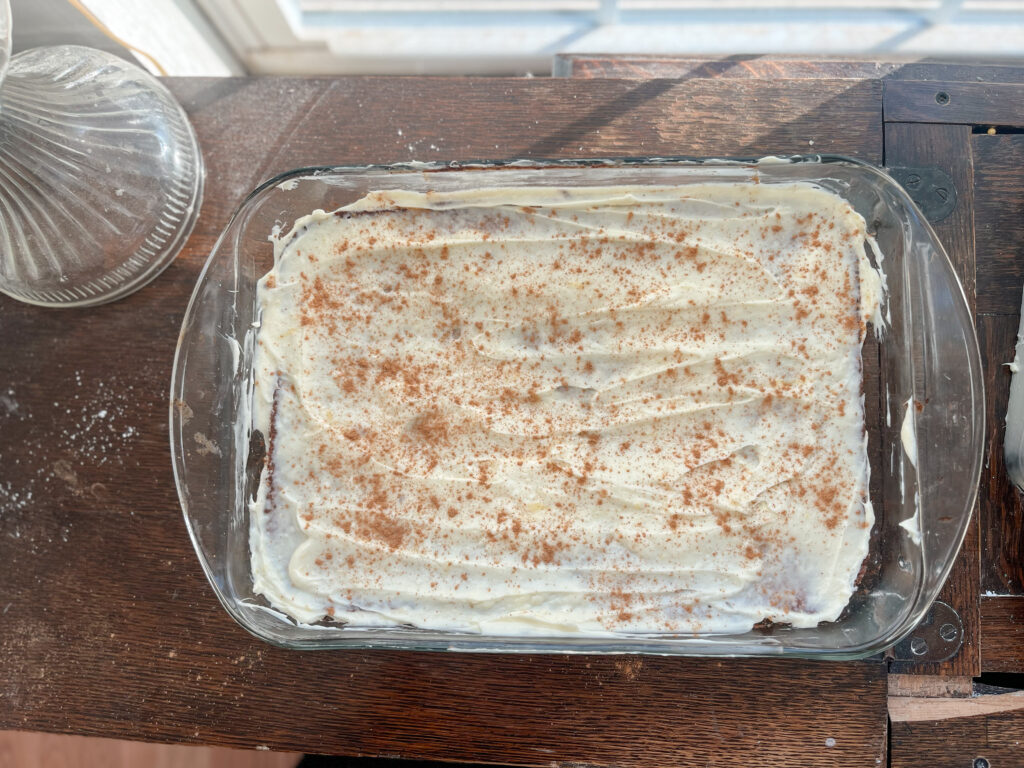 iced einkorn applesauce cake in a glass pan